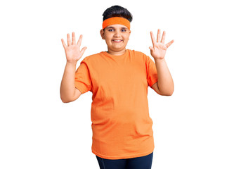 Naklejka premium Little boy kid wearing sportswear showing and pointing up with fingers number ten while smiling confident and happy.