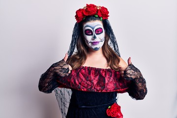 Young woman wearing day of the dead costume over white success sign doing positive gesture with hand, thumbs up smiling and happy. cheerful expression and winner gesture.