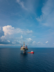 Aerial view from a drone of an offshore jack up rig at the offshore location with a supply boat
