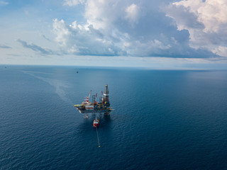 Aerial view from a drone of an offshore jack up rig at the offshore location with a supply boat