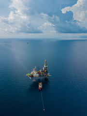 Aerial view from a drone of an offshore jack up rig at the offshore location with a supply boat
