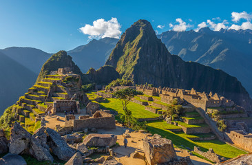The lost inca city of Machu Picchu with the last sun rays illuminating the most famous landscape of Peru, South America. - obrazy, fototapety, plakaty