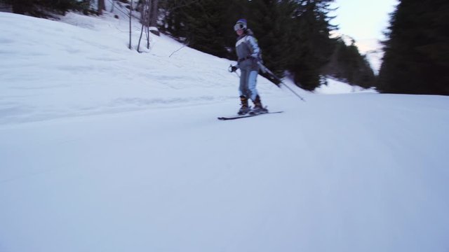 Amateur skier skiing on slopes in the French alps. Beginner girl on skies falling.