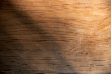 Abstract light and shadow of leaf on wood texture for background.