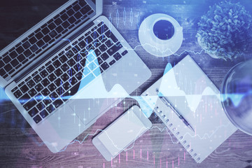 Financial market graph and top view computer on the desktop background. Double exposure. Investment concept.