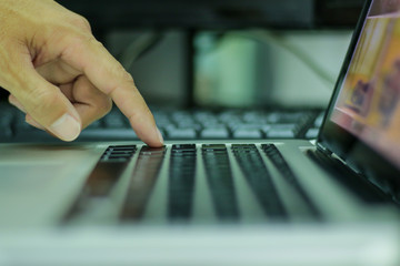 Single finger press on laptop keyboard, close up ..