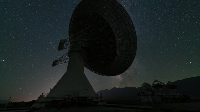 Time lapse tracking shot of Milky Way galaxy over radio observatory in Eastern Sierra, California