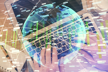 Double exposure of man's hands typing over computer keyboard and business theme hologram drawing. Top view. Financial markets concept.