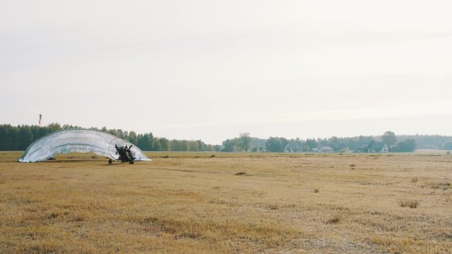 Starting paramotor gliding. Parachut lifting up and take off starts. High quality 4k footage
