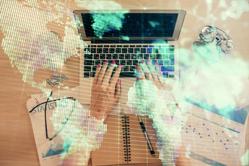 Double exposure of woman hands working on computer and financial theme hologram drawing. Top View. Business concept.