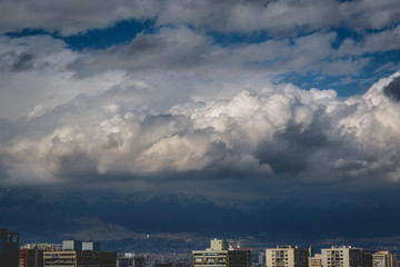 Beautiful and scenic sunlight and cloudy sky over Santiago skyline and the snowed The Andes Mountains, Chile