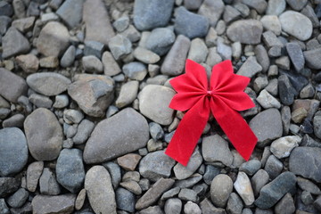 Fototapeta na wymiar Red bow on stones