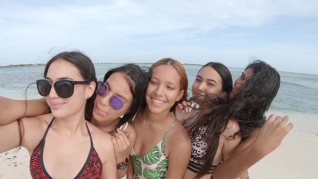 Happy Five young woman tourist friends on summer travel adventure vacation while laughing and taking selfie at the caribbean beach