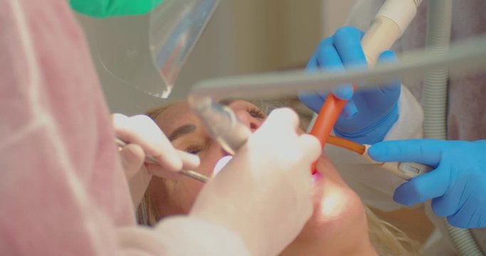 Dentist Treatment on a Female Patient During Covid-19 Virus Outbreak, Close Up. Doctor and Assistent Working With Instruments With Masks and Gloves