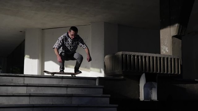 Scater trying to do a trick with a scateboard. Teenager riding a board.