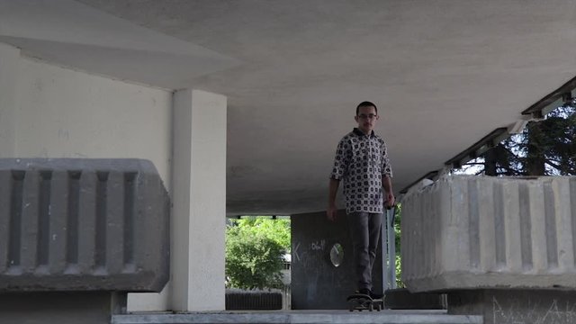 Scater riding a scateboard in an old building. Scater boy scating.
