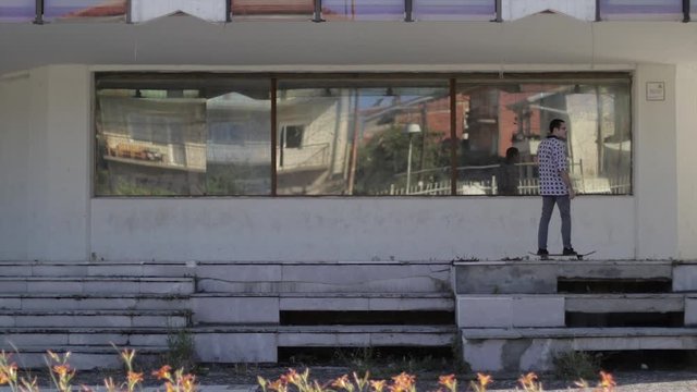 Riding a scateboard in an old building. Young scater boy riding a board.