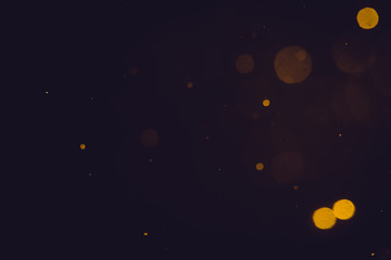 Dark Abstract Gold bokeh sparkle on black background