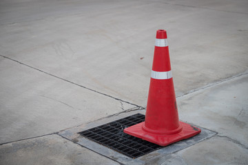 Traffic cone on the asphalt surface with partly rubbed out white road