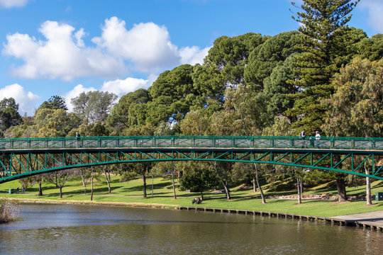 The Adelaide University Footbridge over river Torrens (Karrawirra Parri). People at the park walking, fishing, riding a bike. Adelaide, Australia