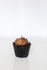 Single chocolate cupcake isolated sitting on a white background