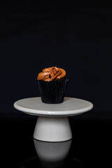 chocolate cake on a white stand with a black background and copy space