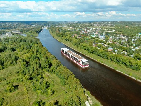 Aerial view journey by passenger cruise ship on the river. Beautiful panoramic landscape from a height ship sails along a large river against the background of water and clouds