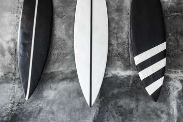 Black and white color surf board on gray concrete wall background. Contemporary interior design of...