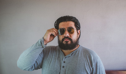 fat latin man with beard wearing aviator glasses