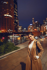beautiful young woman walking near Chicago river at night