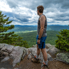 A Long Trail hiker taking in the view from the western cliff of White Rocks Mountain, Vermont