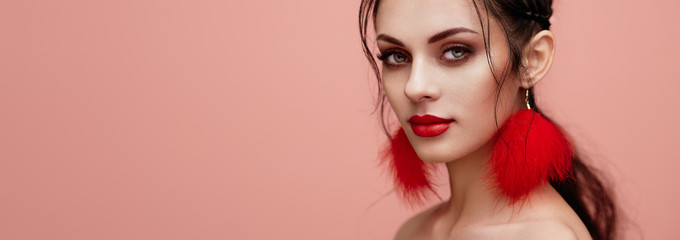 Brunette girl with perfect makeup. Beautiful model woman with curly hairstyle. Care and beauty hair products. Lady with braided hair. Model with jewelry. Pink background