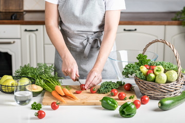 woman cooking in the kitchen. fresh healthy vegetables on a cutting board