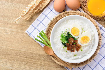Asian breakfast food, Rice soup with boiled egg, grilled mushroom and spinach in bowl