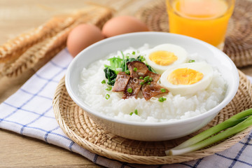 Asian breakfast food, Rice soup with boiled egg, grilled mushroom and spinach in bowl