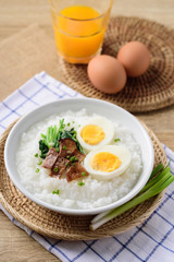Asian breakfast food, Rice soup with boiled egg, grilled mushroom and spinach in bowl
