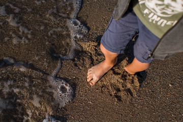 boy feet on the seashore
