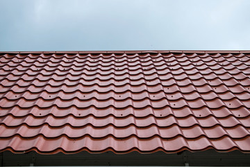 Tiled patterned red roof against a blue sky