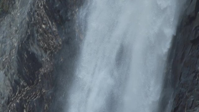 Detail pan down shot in slowmotion of how the water falls in the Venosc waterfall. French Alps. Pro Res