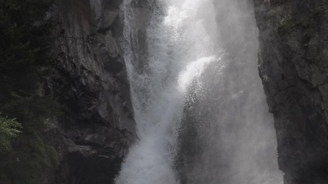 Detail static slowmotion shot of the La Pisse waterfall. The water goes down and up. French Alps. Pro Res