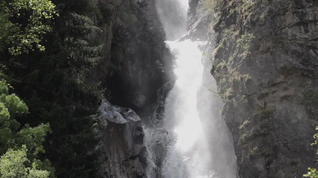 Smooth pan down from the La Pisse waterfall. The sunlight creates beautiful shadows with the water. French Alps. Pro Res