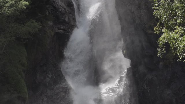 Detail shot in slowmotion of the La Pisse waterfall. The sunlight creates beautiful shadows with the water. French Alps. Pro Res