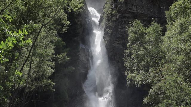 Static shot in slowmotion of the La Pisse waterfall. The sunlight creates beautiful shadows with the water. French Alps. Pro Res