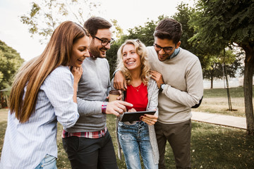 Group of friends in the park hanging out on social networks