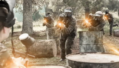 concentrated teams facing on battlefield in outdoor paintball arena during the match