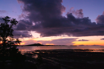 Morning low tide sea view with dark dawn sky.