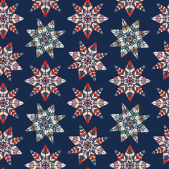 Seamless vector pattern of ornamental lined abstract flower snowflakes on blue