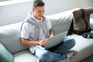 Man with laptop booking tickets online at home