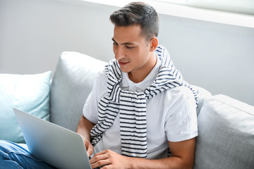 Man with laptop booking tickets online at home