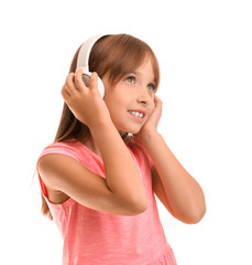 Fototapeta premium Little girl listening to music on white background